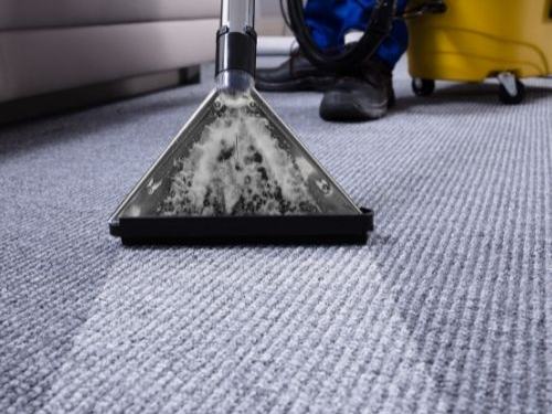 Grey fitted carpet being deep cleaned with an extraction tool
